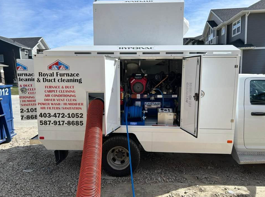 Royal Furnace truck with open equipment doors showing the cleaning machinery and connected red hose